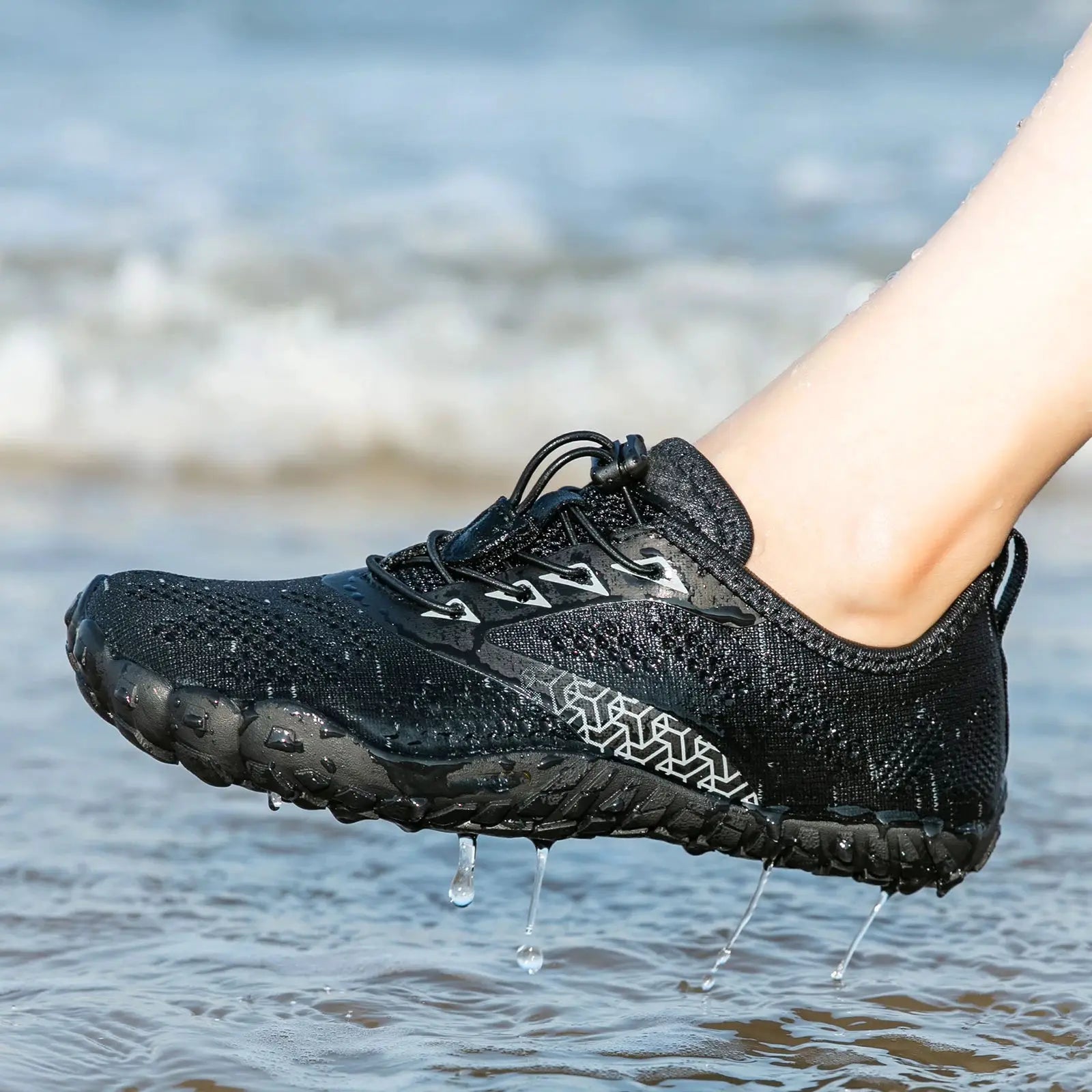 Black trail running shoe with rugged outsole and water droplets