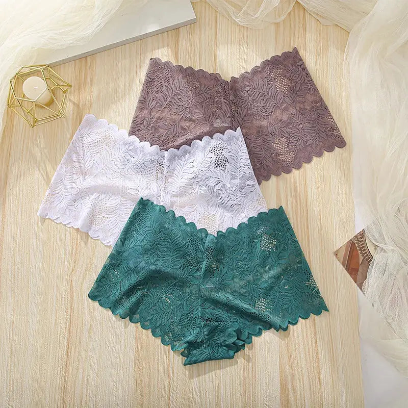 Three-piece women's lace underwear set in teal, white, and purple with floral edges.
