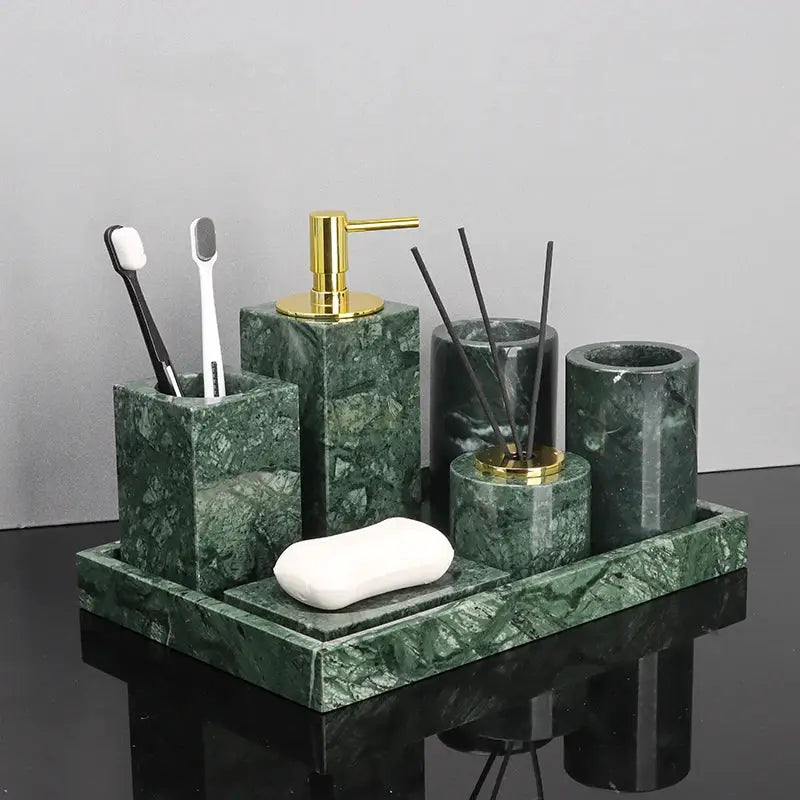 Green marble bathroom set with gold pump dispenser, toothbrush holder, soap dish, and diffuser jars on tray