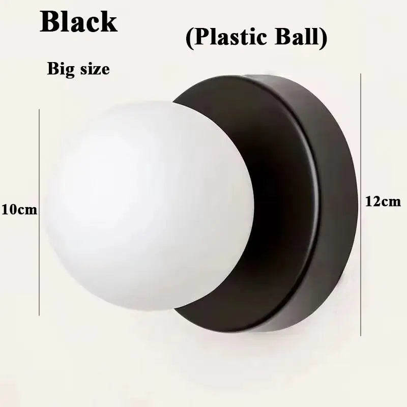 Macaron wall lamp with black iron base and white plastic ball shade; modern sconce