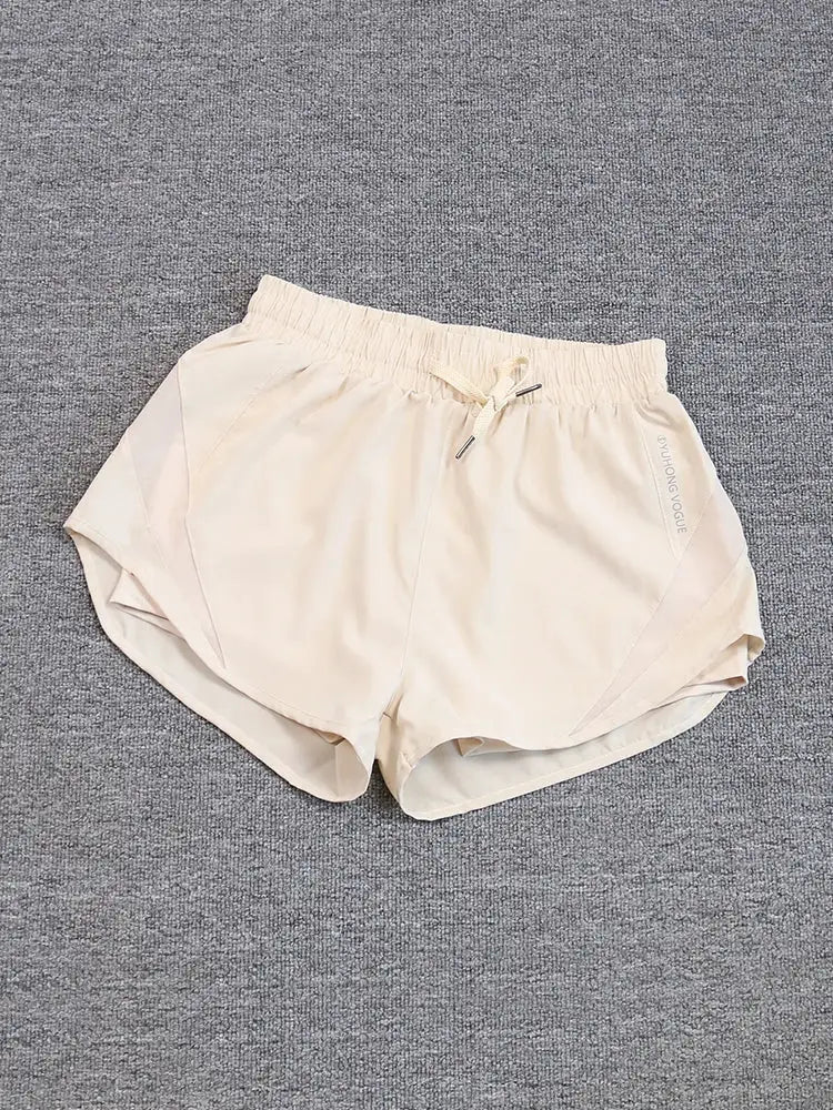 Beige women's running shorts with elastic drawstring waistband, breathable quick-dry fabric, side seam logo.