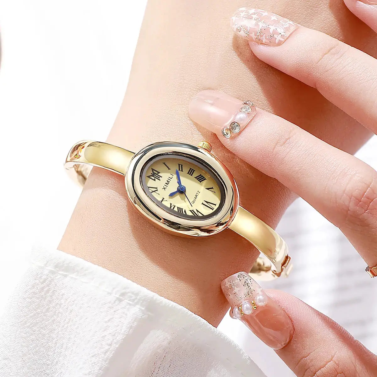 Women's gold-tone quartz wristwatch with oval case, Roman numerals, blue hands, Simples Market