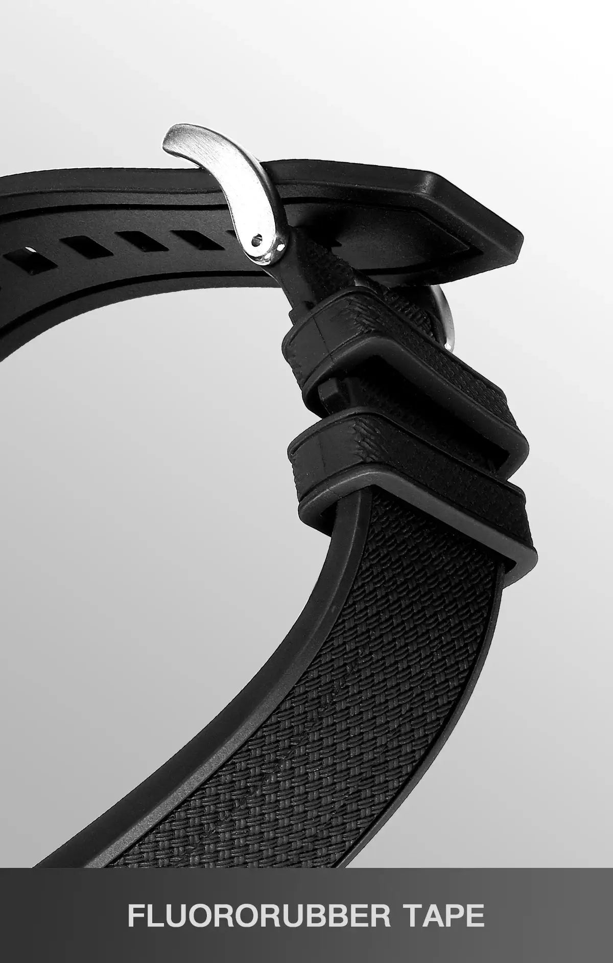 Black fluororubber watch strap with metal tang buckle, close-up.