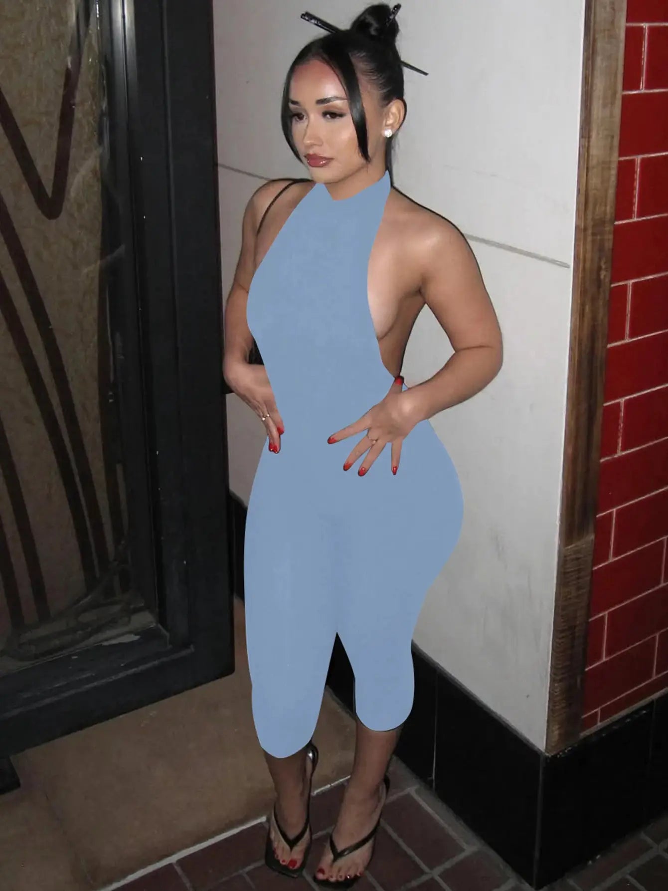 Hugcitar ribbed halter backless blue bodycon jumpsuit worn by a woman with black strappy heels