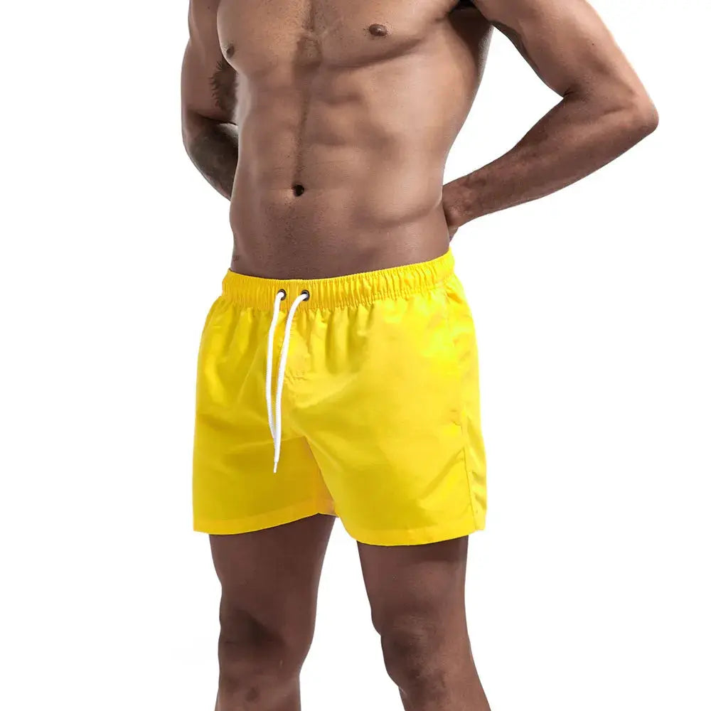 Men's yellow swim trunks with white drawstring and elastic waistband.