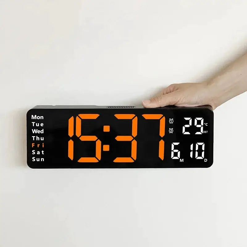 Large digital wall clock with orange LED display showing time, weekday, date and temperature on black panel