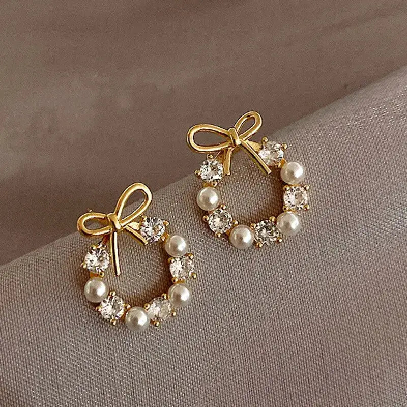 Hollow-out round rhinestone bow stud earrings with imitation pearls, gold-tone pair for women