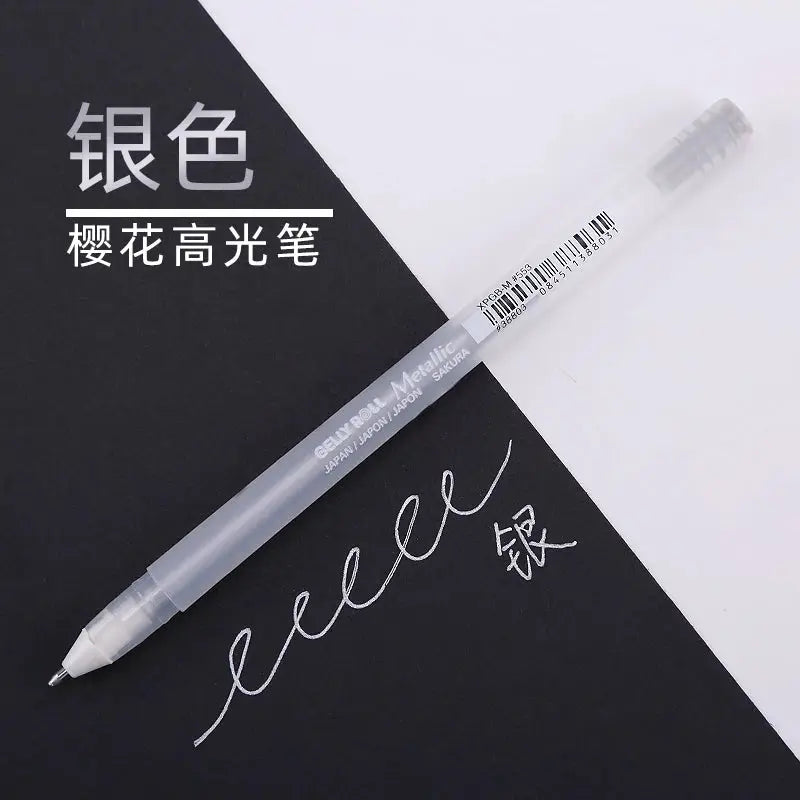 Sakura Gelly Roll gel pen in silver metallic ink; translucent barrel with SAKURA branding, ideal for journaling and art.