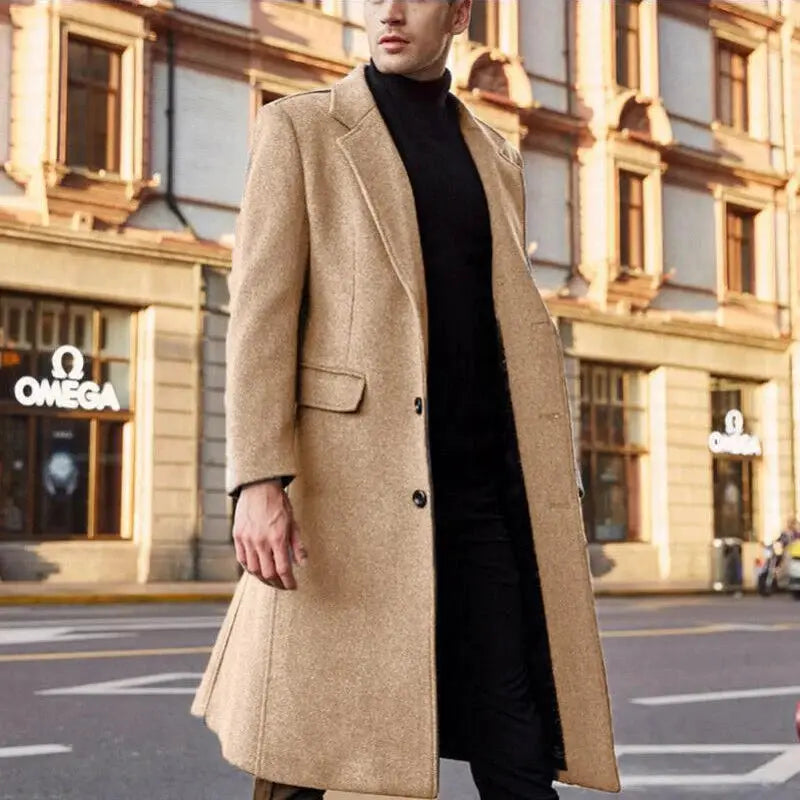 Simples Market men's camel wool coat, long overcoat on a man in black, with Omega storefront visible in the background.