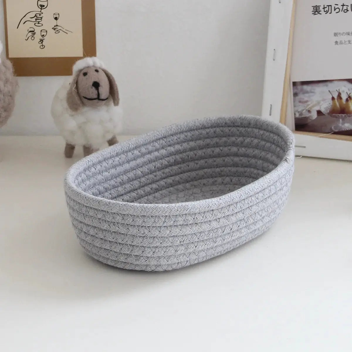 Gray woven storage basket, oval desktop organizer for cosmetics, toys, and stationery.