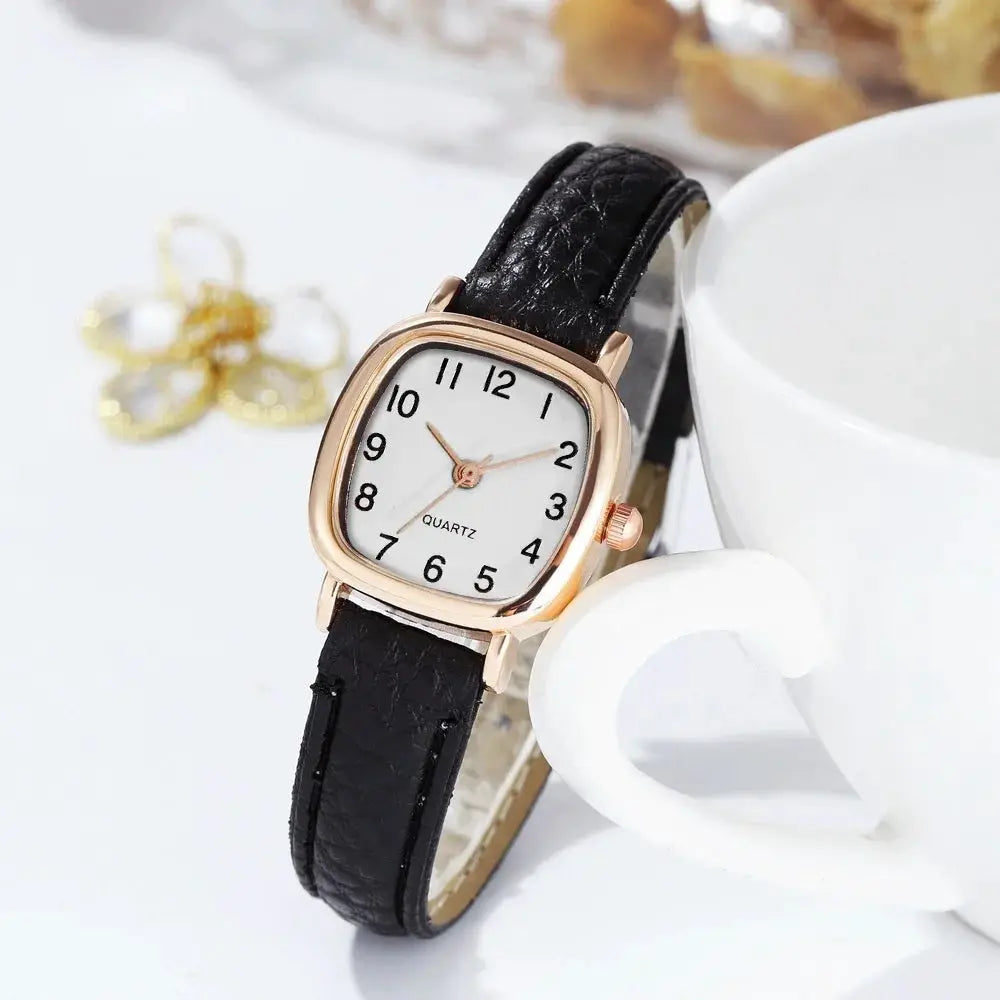 Women's watch with rose-gold case and black leather strap; white dial with Arabic numerals