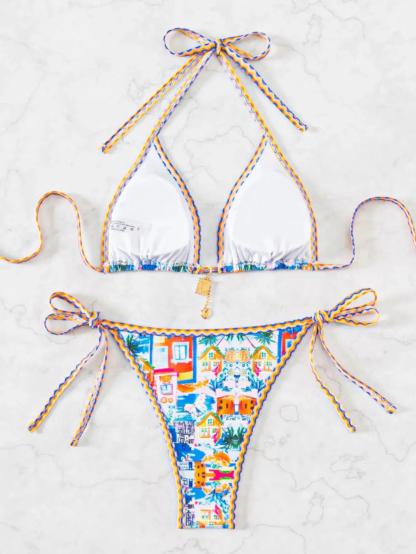 Simples Market 2026 Triangle Bikini Set with white triangle top and colorful printed Brazilian bottoms, braided trim.