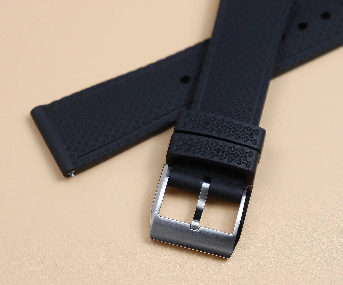 Cronos watch strap, black rubber with a textured pattern and silver buckle.