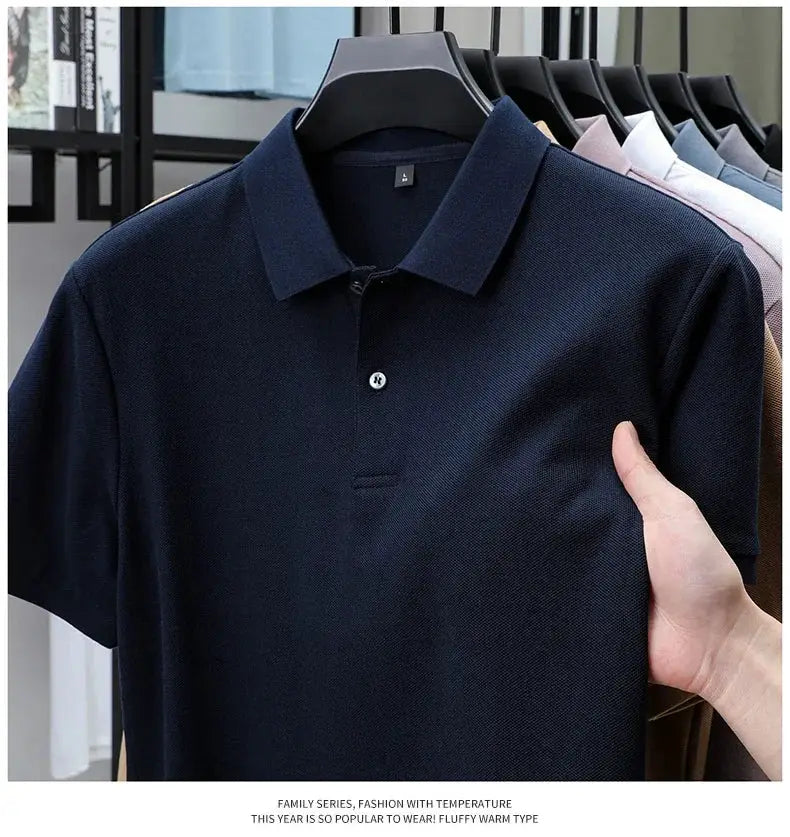 Men's 100% cotton polo shirt in navy on hanger; other color options visible in background