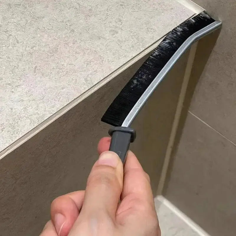 Durable grout cleaning brush with black bristle strip and gray handle for tile joints.