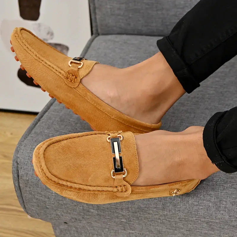 Pair of men's tan suede loafers with gold horsebit hardware, slip-on driving moccasins.