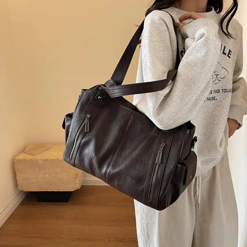 Shoulder bag in black PU leather with soft interior compartment and multiple zip pockets