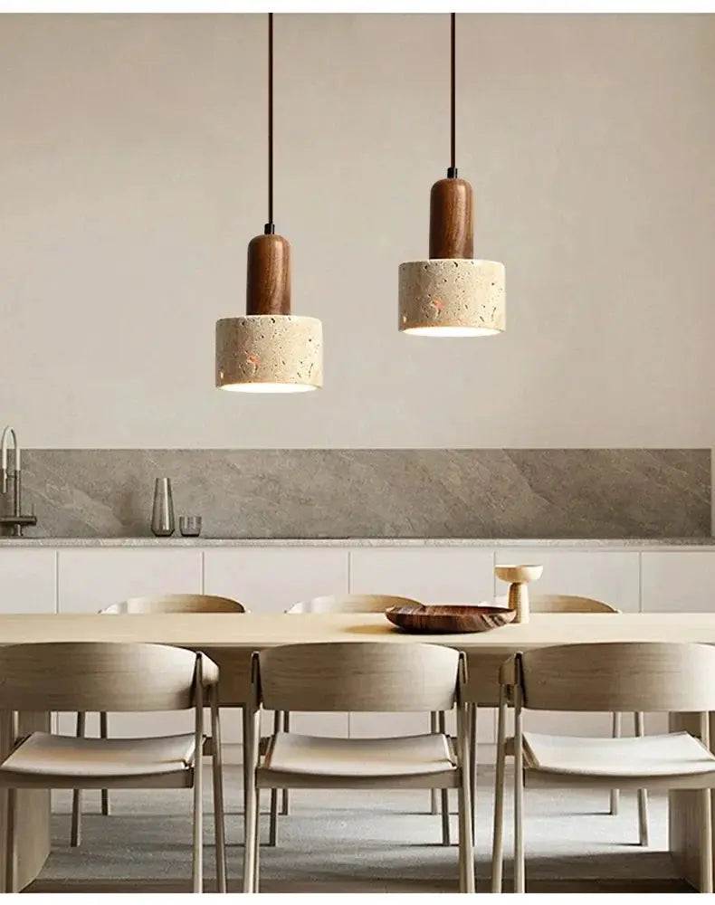 Travertine droplight pendant lamp pair with wood accents over a dining table in a minimalist kitchen