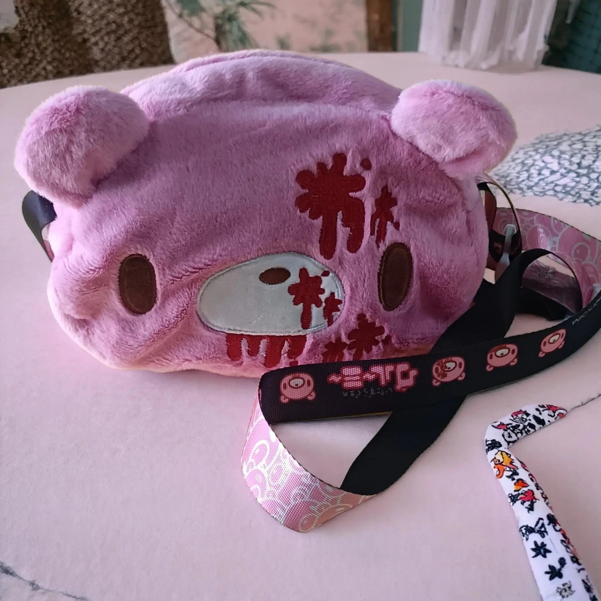 Gloomy Bear plush crossbody bag in pink with a white face patch, brown eyes, and red blood-splatter details.