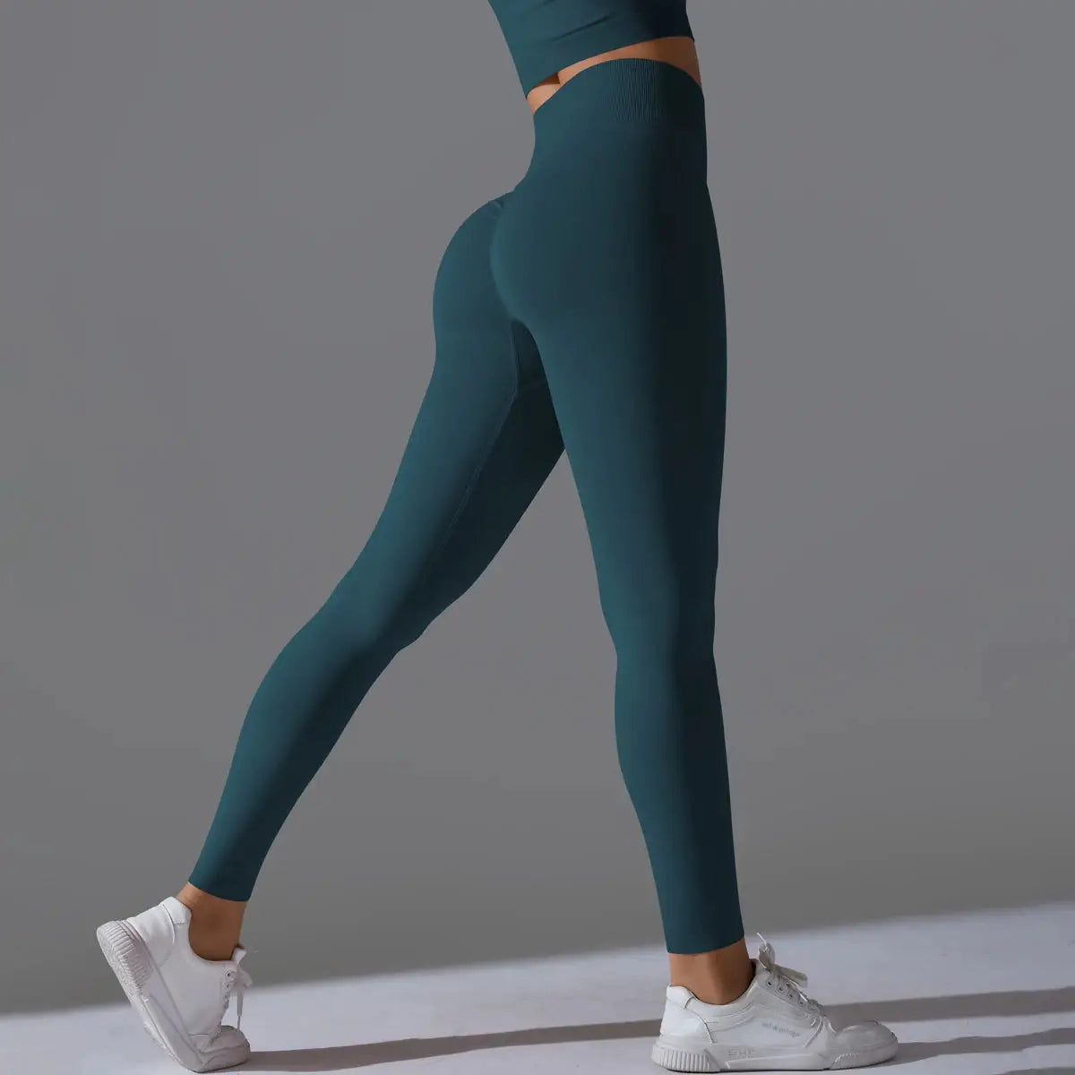 Women's seamless yoga leggings in teal with high-waist tummy control and scrunch butt lifting for gym workouts.