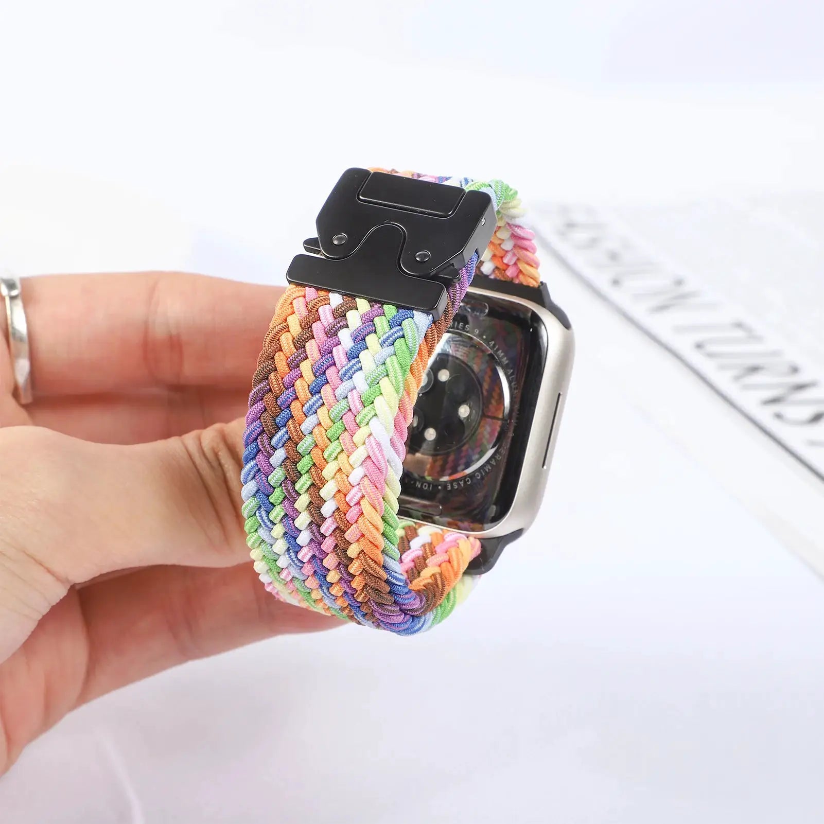 Simples Market parachute braided Apple Watch strap in rainbow colors with a black buckle, fits 41–49mm
