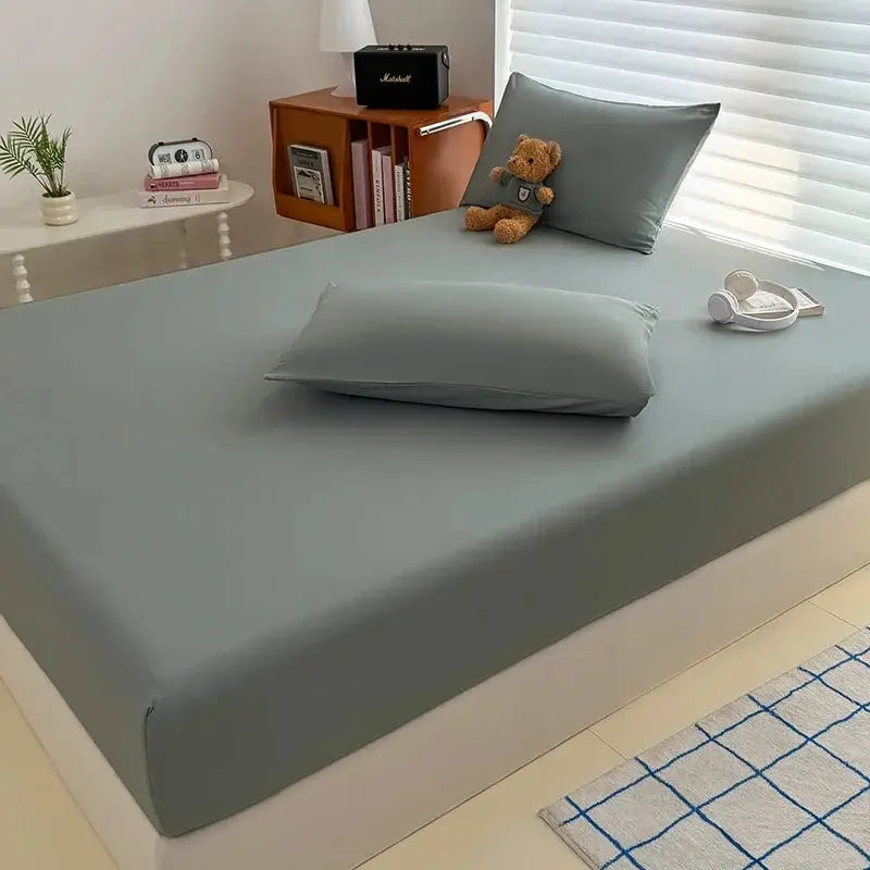 Simples Market washed fitted sheet with elastic bands in gray on a bed with two matching pillowcases