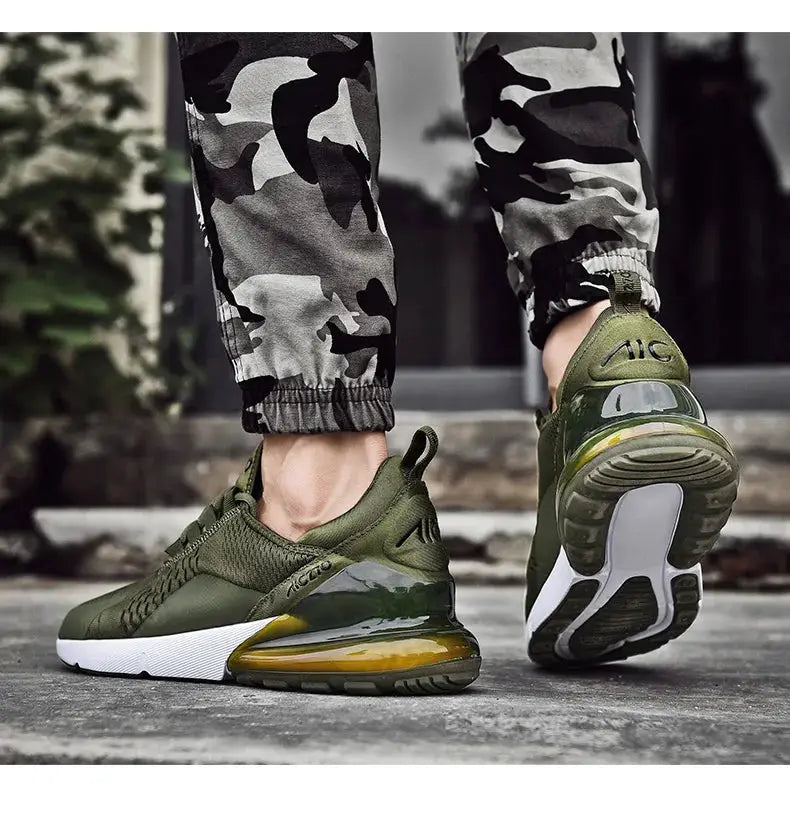 Pair of men's olive green Simples Market sneakers with breathable mesh, white midsole, and yellow-orange air cushion.