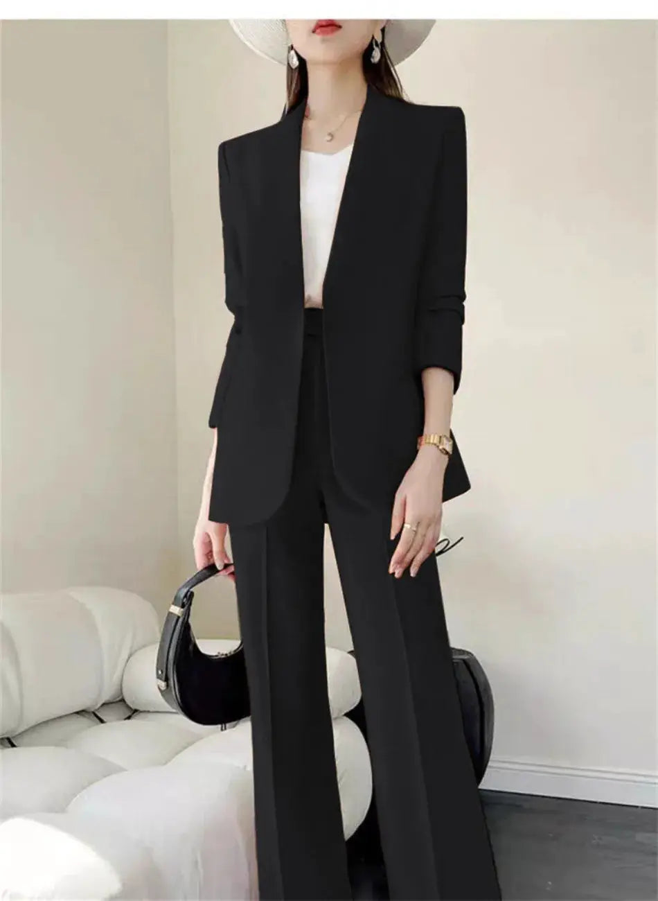 Black 2-piece women's pantsuit with blazer and wide-leg pants, white top, accessorized with handbag
