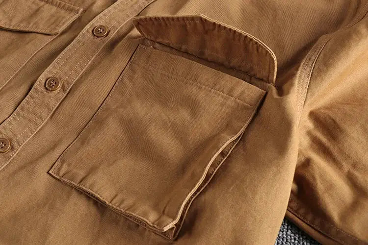 Khaki work shirt with front patch pocket, button placket, loose fit.