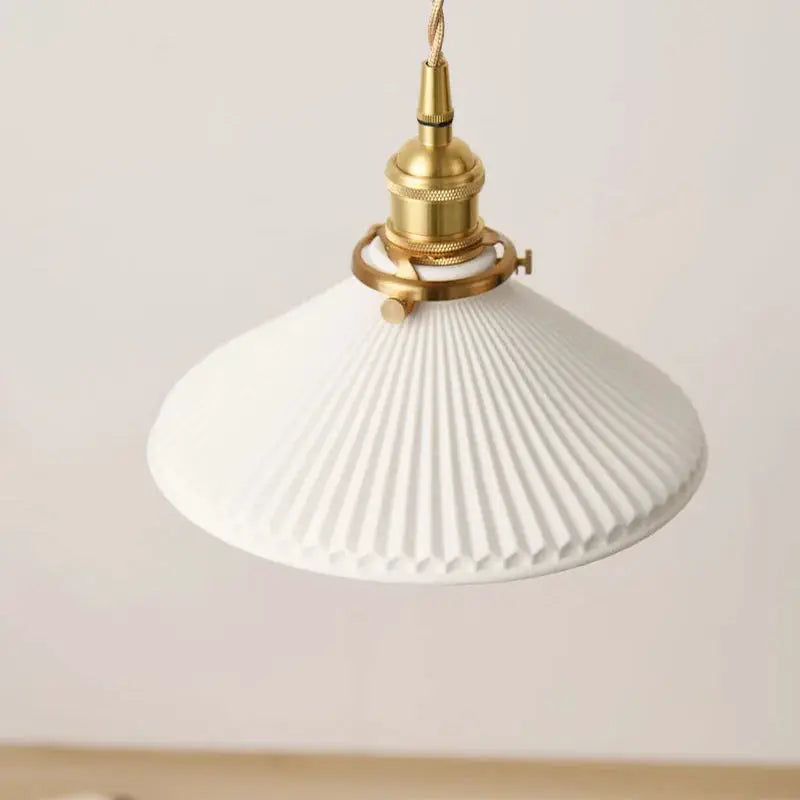 Ceramic pendant light with white ribbed shade and brass hardware.