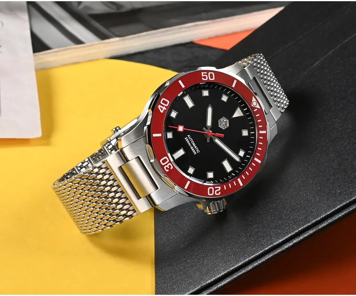 San Martin Original Design Diver watch with red bezel, black dial, luminous markers, and stainless steel Milanese mesh bracelet.