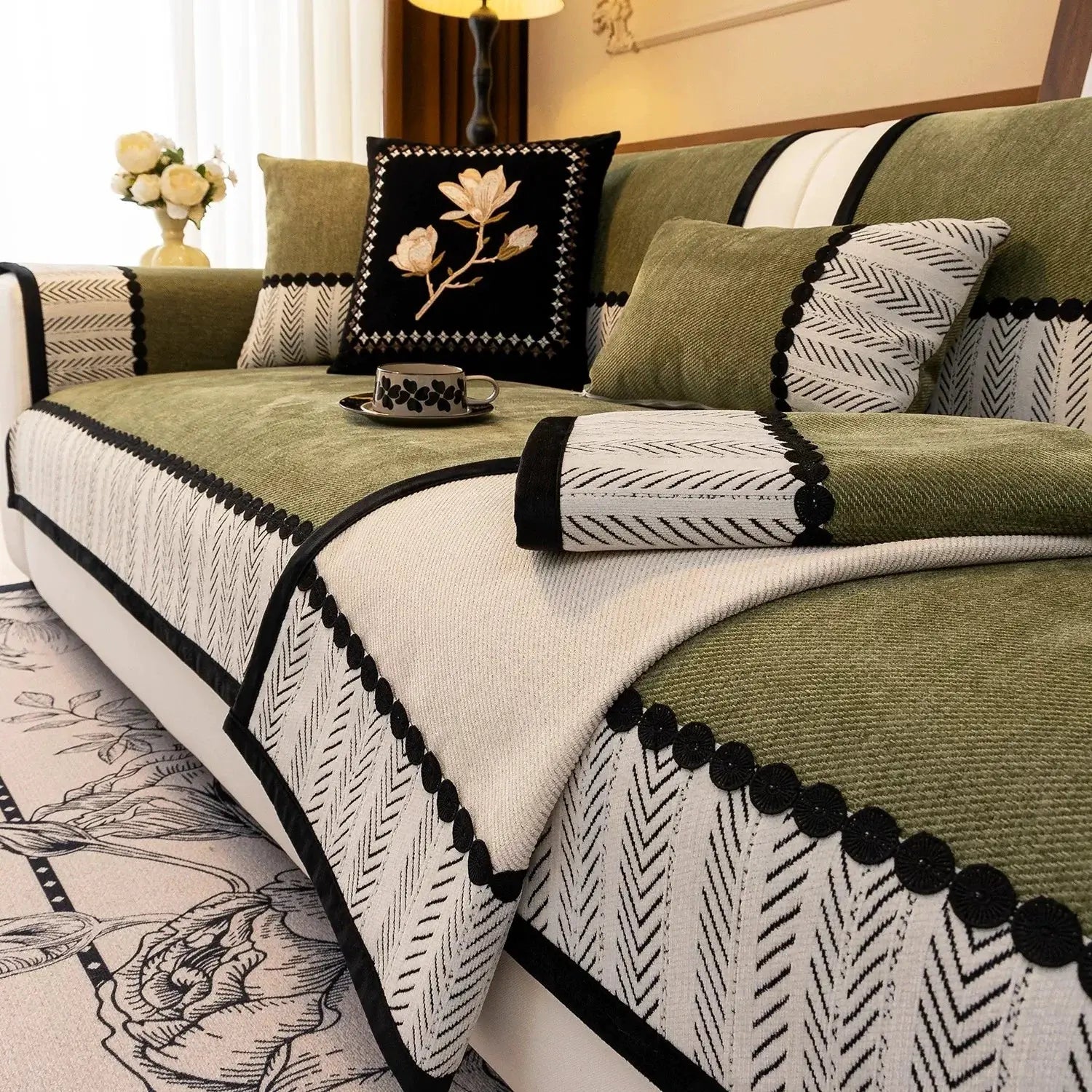 Contrast Hem Twill Chenille sofa cover in olive-green and cream with black pom-pom trim
