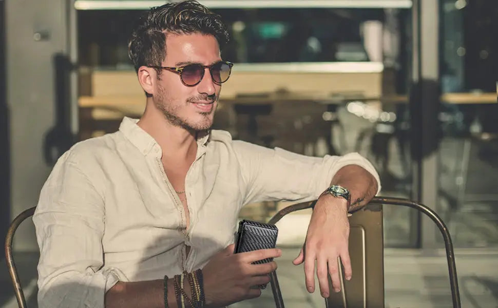 Men's wallet by Simples Market; slim black RFID-blocking wallet held by a man in a white shirt