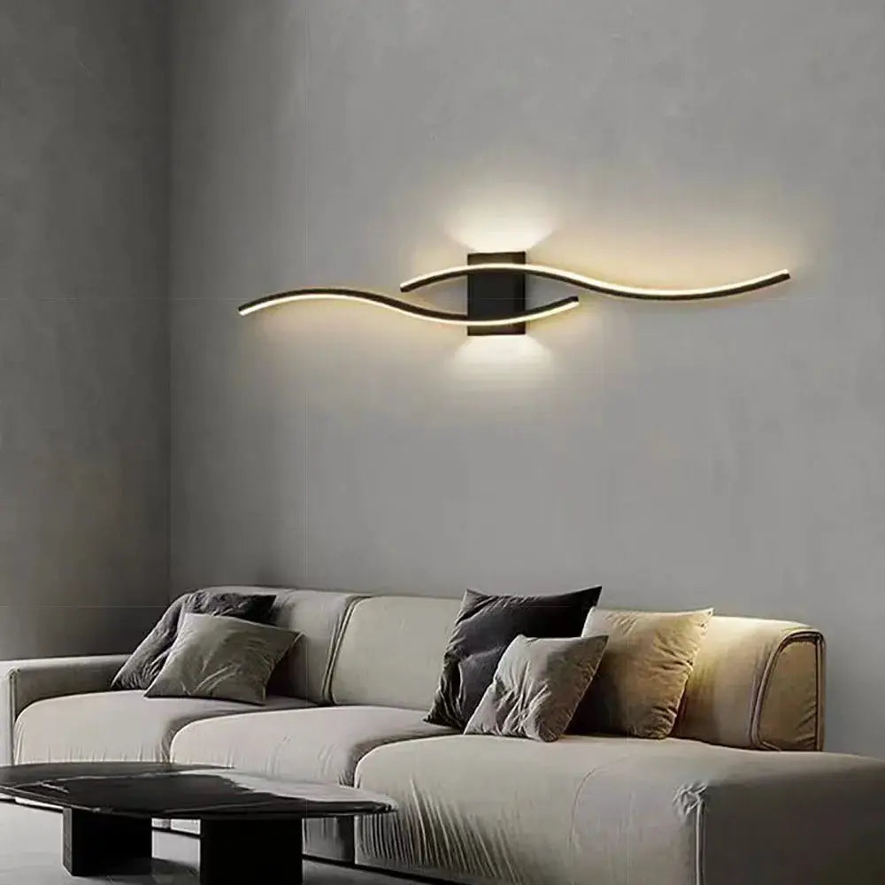 Moder LED wall lamp with gold-tone curved light strips, wall-mounted above sofa in modern living room.