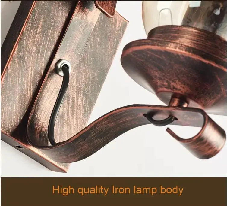 Wall lamp by Simples Market, wrought iron with rustic brown finish and curved scroll arm.