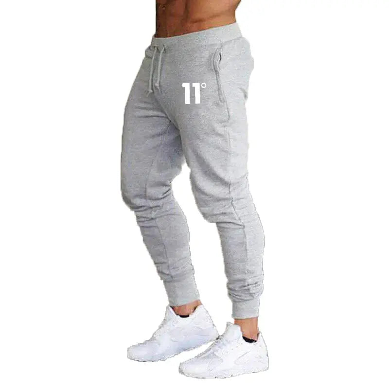 Joggers by Simples Market, grey with drawstring waist, cuffed ankles, 11° logo.