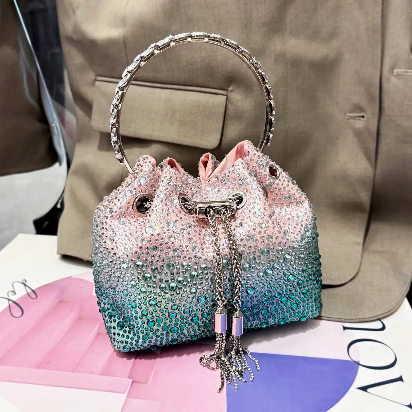 Rhinestone evening clutch bag with crystal ring handle in pink-to-teal gradient