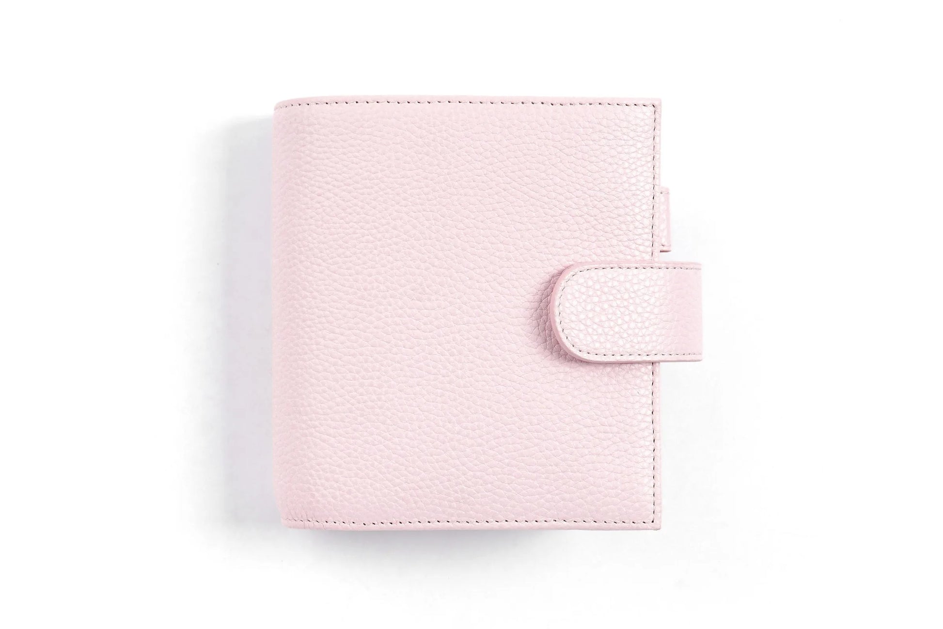 Moterm Luxe 2.0 pocket-size planner in pink pebble-grain leather with strap closure.