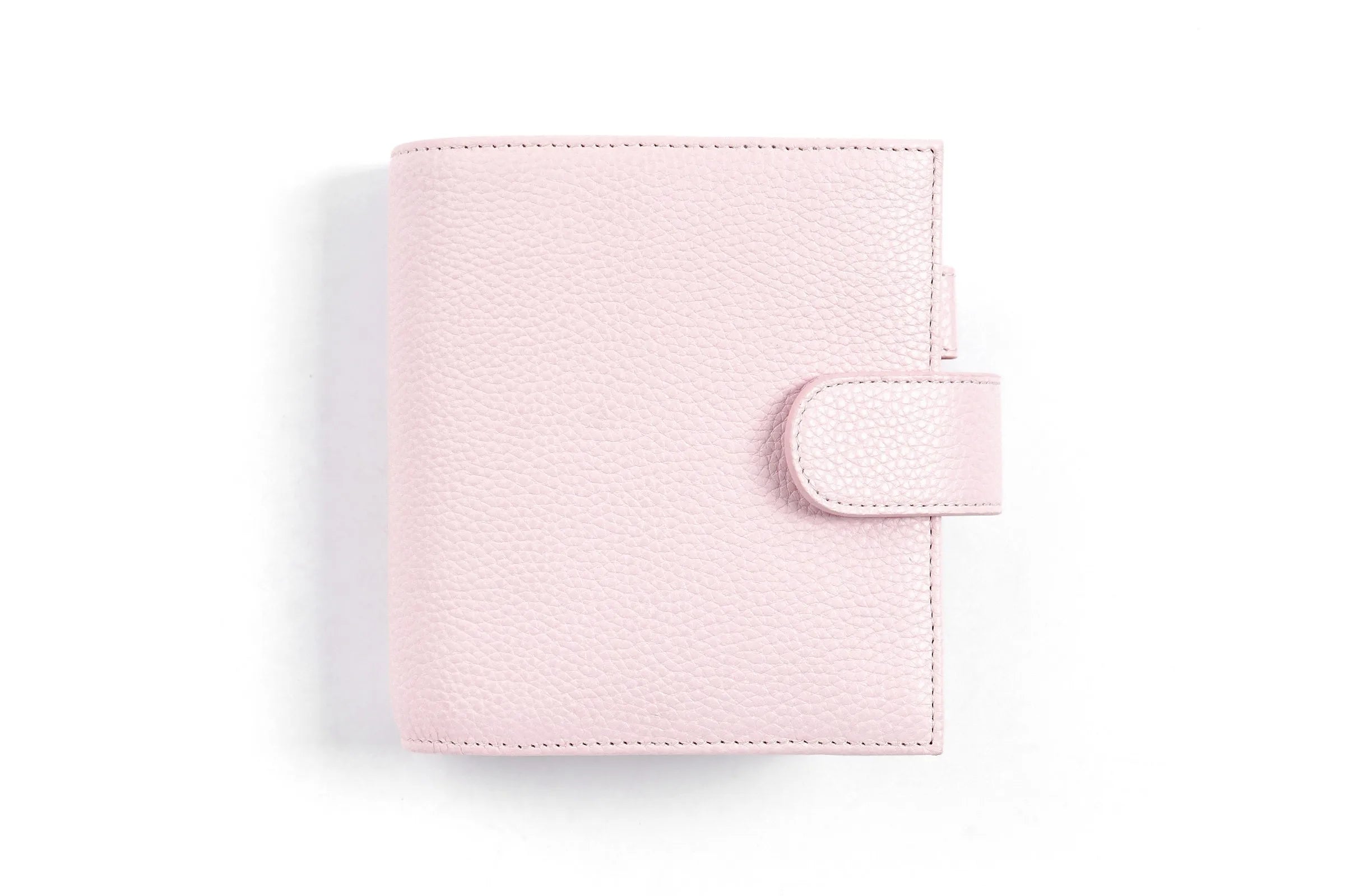 Moterm Luxe 2.0 pocket-size planner in pink pebble-grain leather with strap closure.