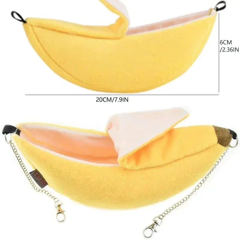 Banana-shaped hamster bed hammock by Simples Market, yellow plush with pink lining and metal chain straps.