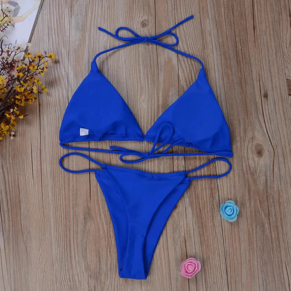 Blue 2-piece bikini set with triangle cups and adjustable side-tie bottoms on a wooden background.