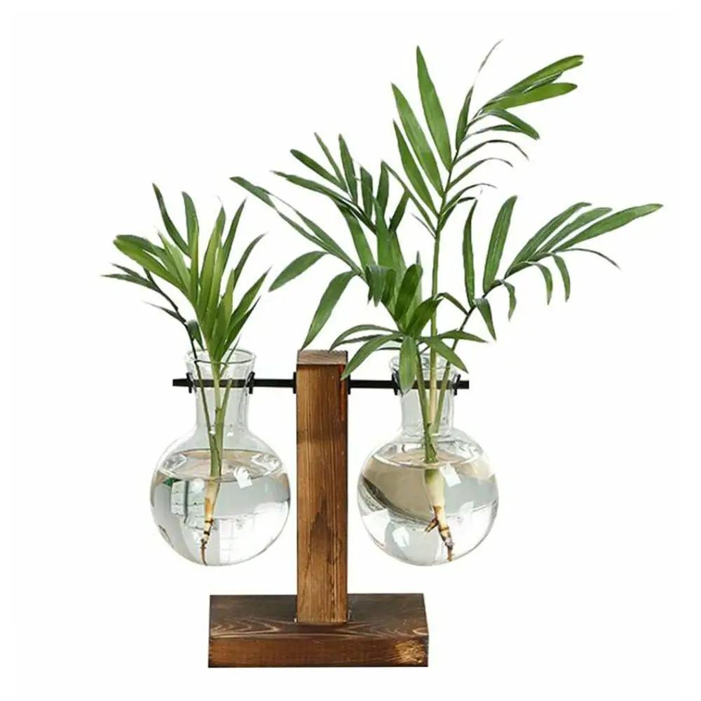 Glass desktop planter with dual bulb vases on a wooden stand by Simples Market