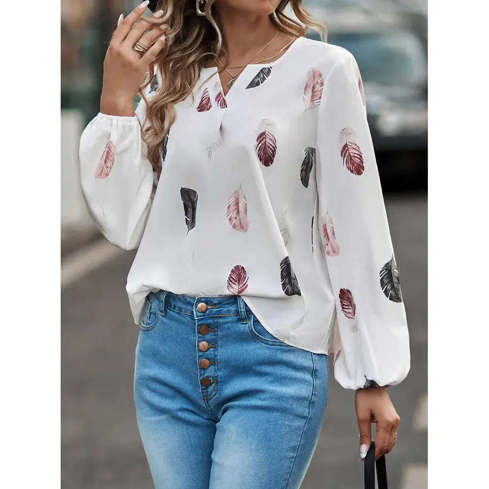 Feather-print chiffon blouse in white with long puff sleeves and V-neck.