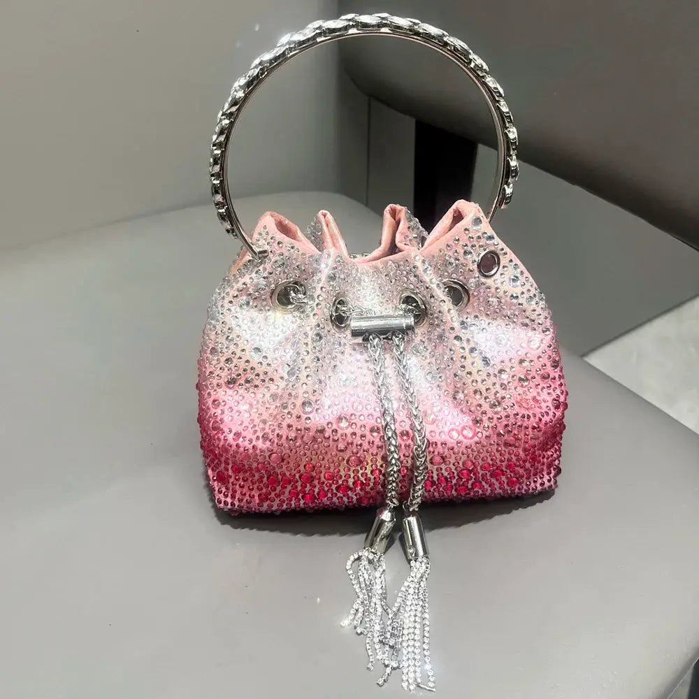 Rhinestone evening clutch bag pink gradient crystal-embellished bucket bag with tassel drawstrings.