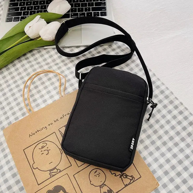 Black shoulder messenger bag with adjustable strap and front zip pocket, compact crossbody phone bag
