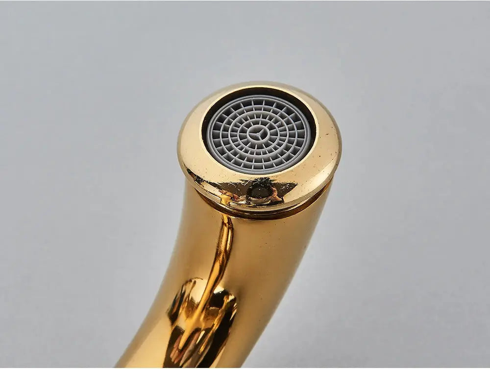 Gold-tone antique bathroom faucet spout with round aerator, deck-mounted style.