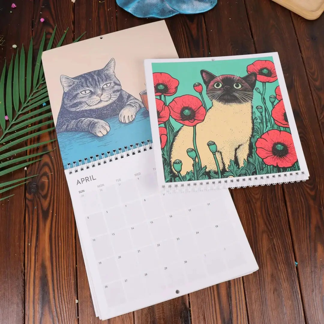 Two Creative Family Planner cat-art calendars, spiral-bound hanging wall calendars featuring handmade cat artwork.