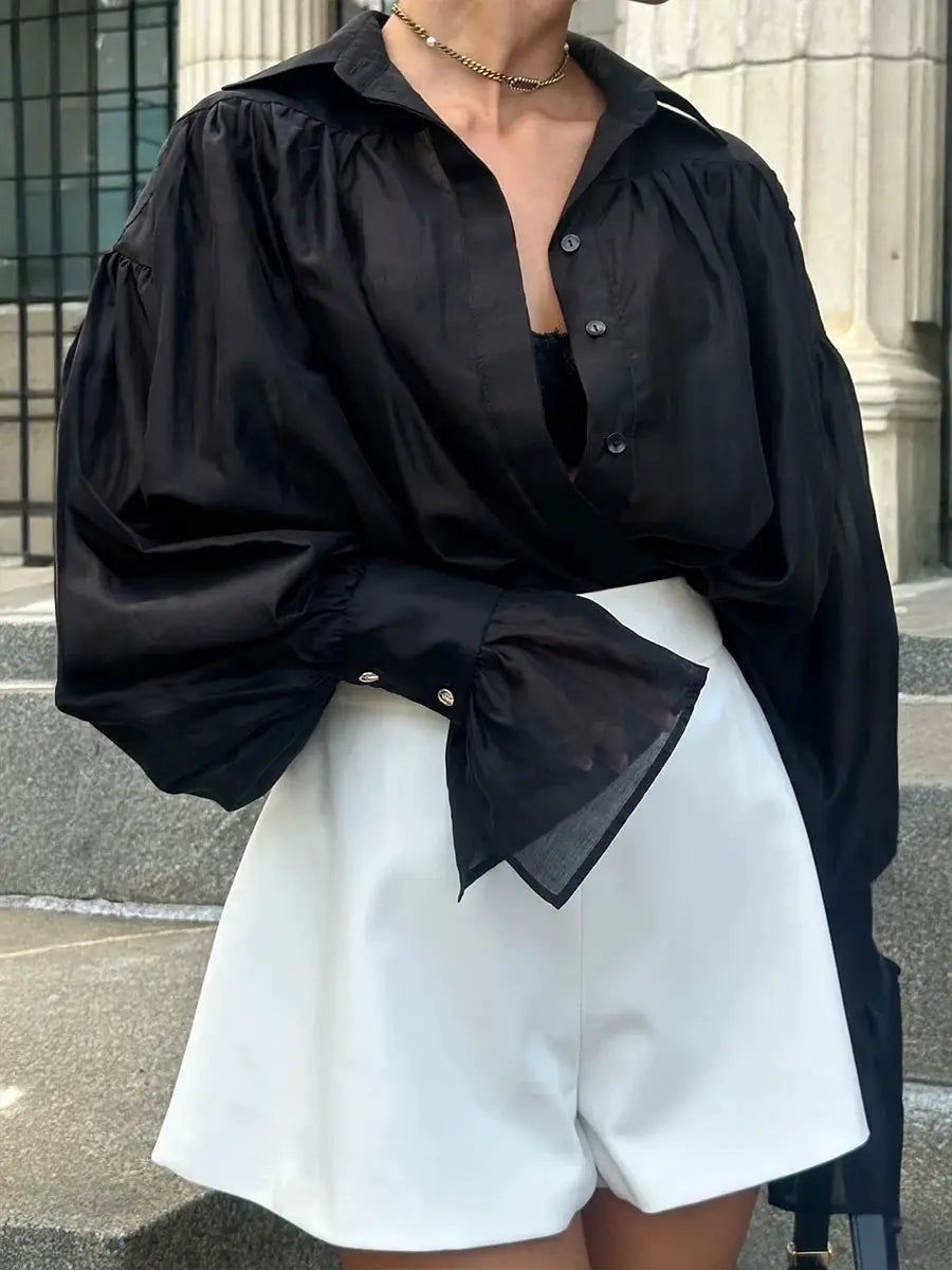 Black loose collared shirt with dramatic puff sleeves and wide cuffs, solid color