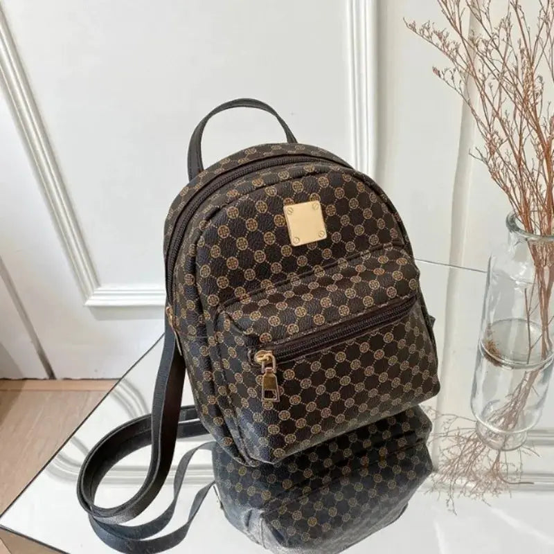 Backpack, brown monogram pattern with gold hardware, front zip pocket, top handle, adjustable straps