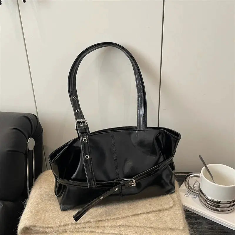 Black soft leather handbag with belt-buckle strap and dual handles; casual Korean-style shoulder bag